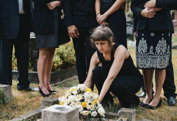 Family Laying Flowers on Grave